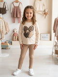 Niña con conjunto leggings beige y camiseta de corazones